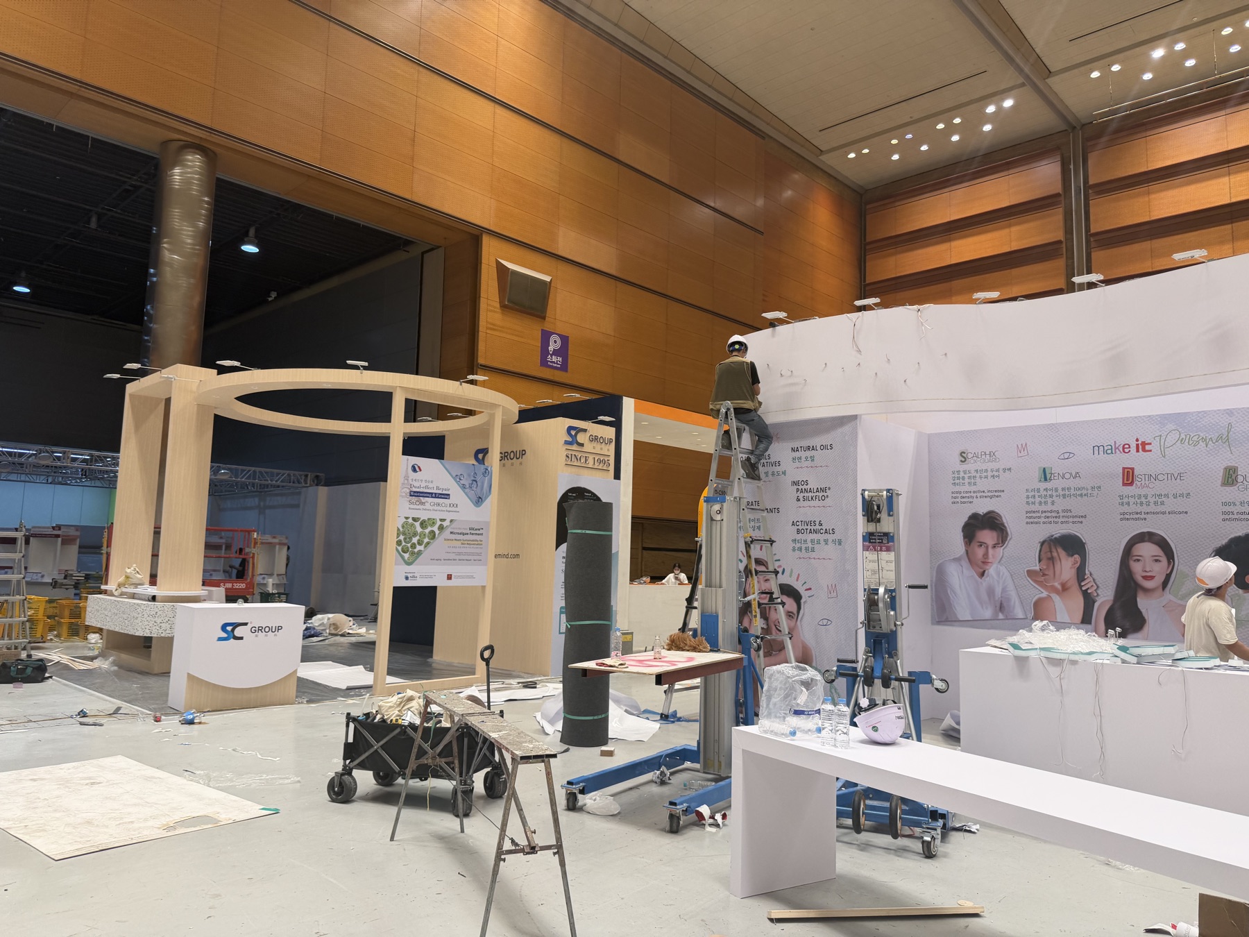 韩国展馆施工人员登梯安装展位顶部结构